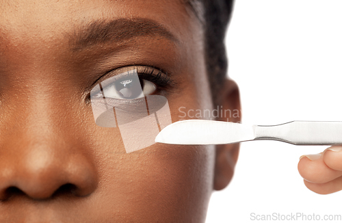 Image of face of african american woman and scalpel knife