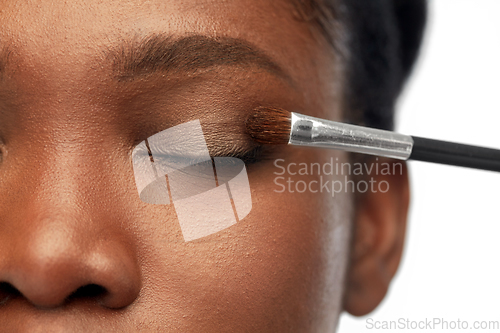 Image of face of african woman and hand with make up brush