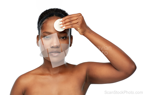 Image of african woman cleaning face with cotton pad