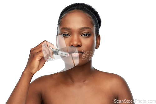 Image of african american woman applying lipstick