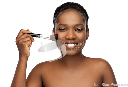 Image of woman with make up brush applying blush to face