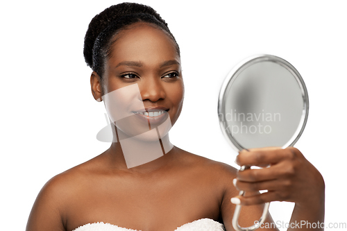 Image of smiling african american woman looking to mirror