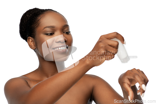 Image of smiling african american woman with moisturizer