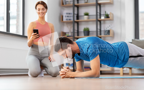 Image of happy couple exercising at home