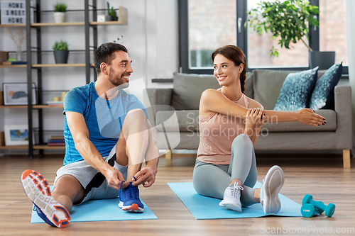 Image of happy couple exercising at home