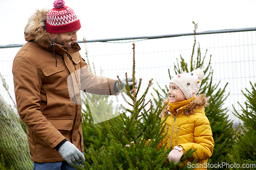 Image of happy family choosing christmas tree at market