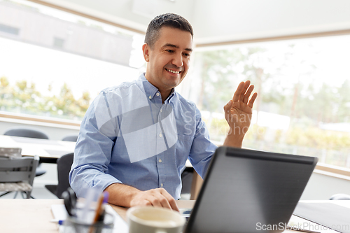 Image of man with laptop having video call at home office