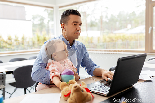 Image of father with baby working at home office