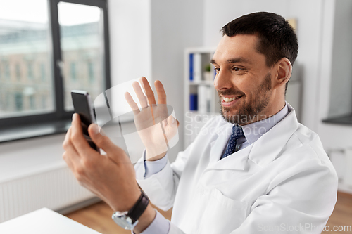 Image of doctor with smartphone having video call at clinic