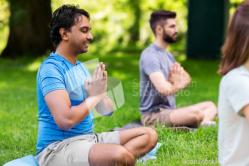 Image of group of happy people doing yoga at summer park