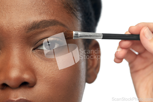 Image of face of african woman and hand with make up brush