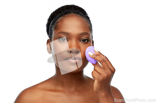 Image of african american woman with make up sponge