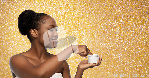 Image of smiling african american woman with moisturizer