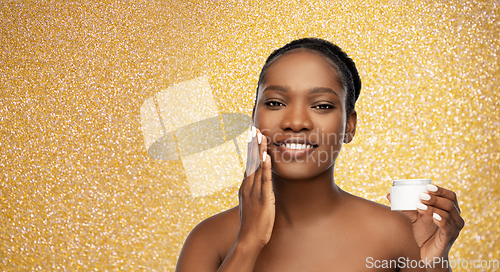 Image of smiling african american woman with moisturizer