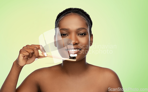 Image of african woman cleaning teeth with toothbrush