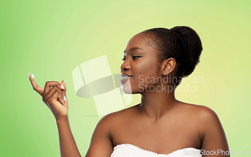 Image of smiling african american woman with moisturizer