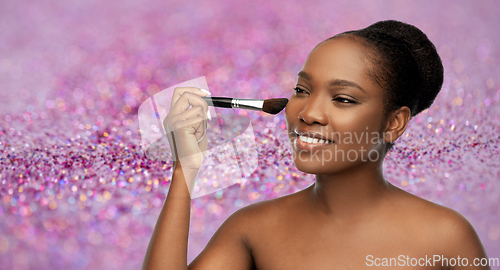 Image of woman with make up brush applying blush to face