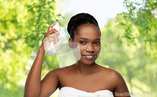 Image of young african woman with hairspray