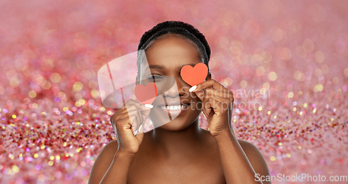 Image of smiling african american woman with red hearts