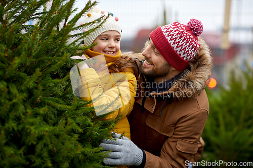 Image of happy family choosing christmas tree at market