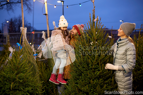 Image of happy family choosing christmas tree at market