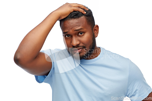 Image of unhappy young african american man touching hair