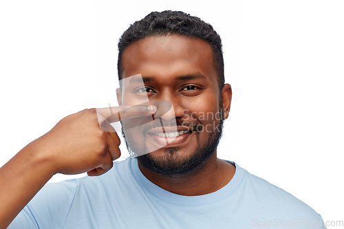 Image of african american man pointing finger to his nose