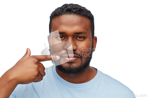 Image of african american man pointing finger to his mouth