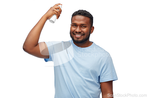 Image of african american man applying hairspray to hair