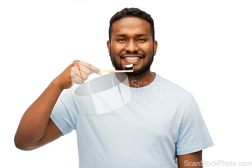 Image of smiling african man with toothbrush cleaning teeth