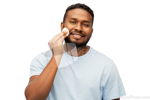 Image of african american man cleaning face with cotton pad