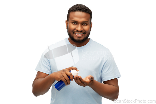 Image of happy african man applying shaving foam to hand