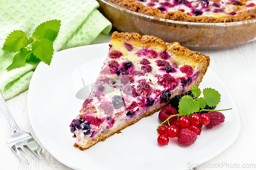 Image of Pie with raspberries and currants in plate on wooden board