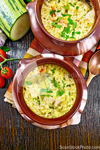 Image of Rice with chicken and vegetables in two pots on board top