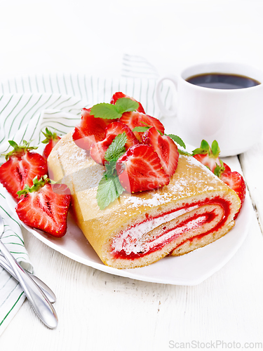 Image of Roll with cream and strawberries in plate on light board