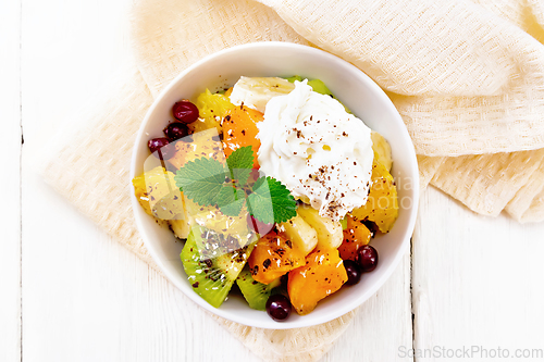 Image of Salad fruit with cranberries and cream in bowl on board top