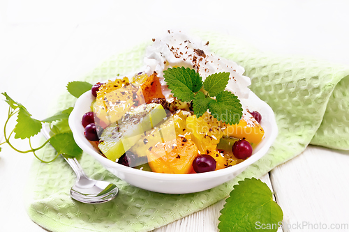 Image of Salad fruit with cranberries in bowl on board