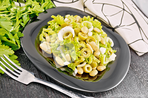 Image of Salad of beans and olives in plate on black board