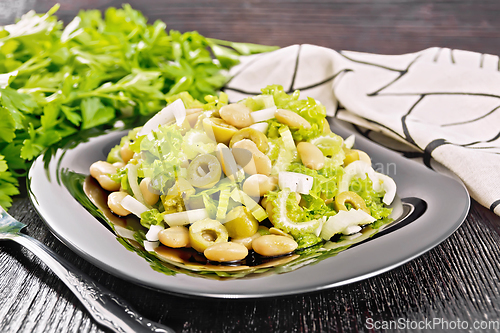 Image of Salad of beans and olives in plate on board