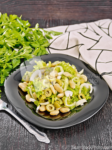 Image of Salad of beans and olives in plate on towel