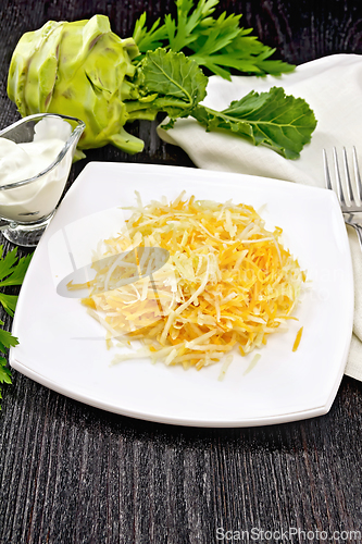 Image of Salad of carrot and kohlrabi in plate on dark board