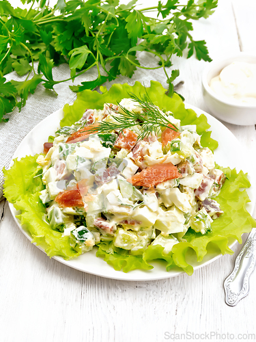 Image of Salad of salmon and avocado with mayonnaise on light board