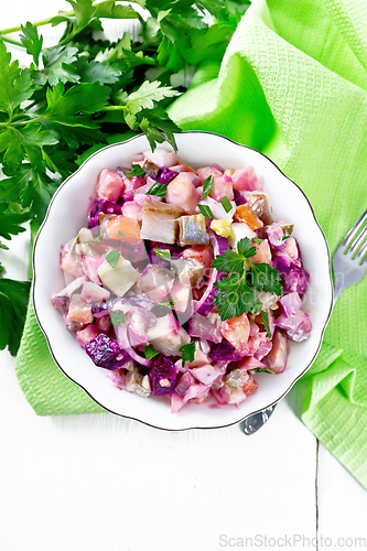 Image of Salad with herring and beetroot in bowl on light board top
