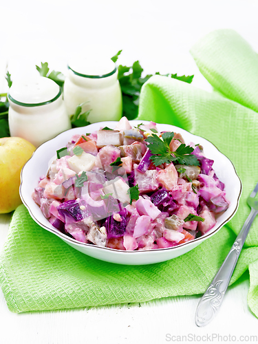 Image of Salad with herring and beetroot in bowl on napkin