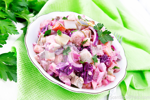 Image of Salad with herring and beetroot in bowl on white board