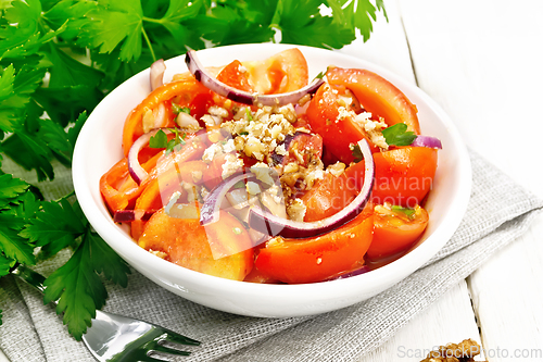 Image of Salad with tomato and walnut in plate on light board