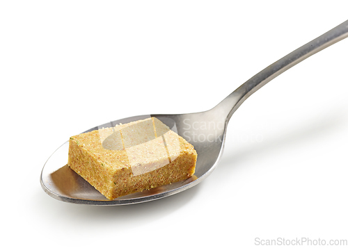 Image of instant chicken broth cube in a spoon