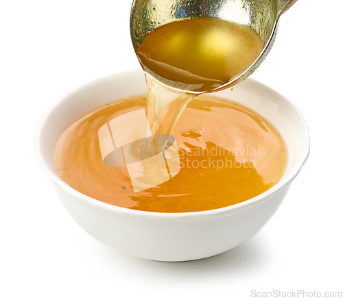 Image of chicken broth pouring into bowl