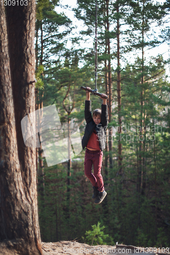 Image of Teen boy at bungee in autumn forest