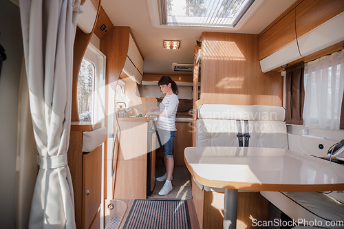 Image of Woman cooking in camper, motorhome interior